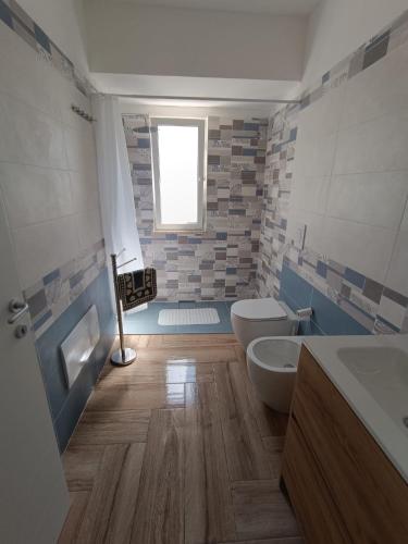 a bathroom with two toilets and a tub and a sink at Solleone - Appartamento 2B in Paestum