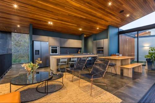 a kitchen with wooden ceilings and a table and chairs at Villa de lujo frente a la represa del Peñol in La Pradera