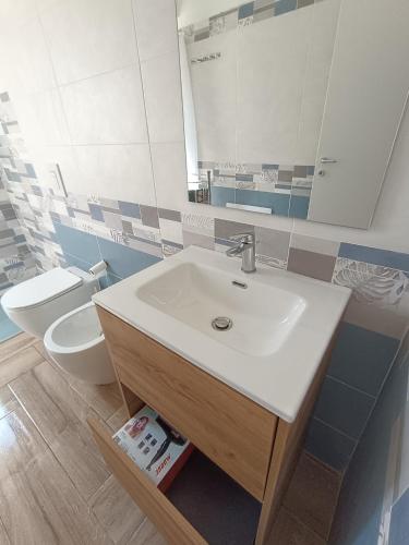 a bathroom with a sink and a toilet at Solleone - Appartamento 2B in Paestum