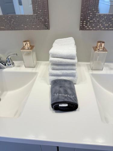 a pile of towels sitting on a bathroom counter next to two sinks at Queen City family-friendly entire house, Charlotte in Charlotte