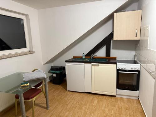 una piccola cucina con un lavello e un tavolo di Günstige Monteurwohnungen östlich von Leipzig Nähe A14 in Wurzen a Wurzen
