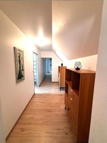 a room with a hallway with a wooden floor at Grande maison avec tranquillité garantie in Lessay