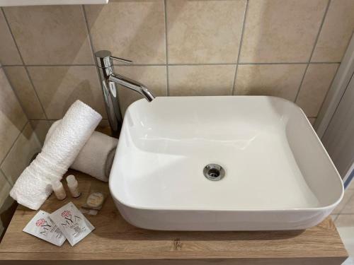 a white sink in a bathroom with a roll of toilet paper at Il Tramonto in Altino