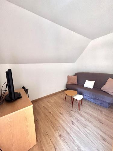 a living room with a couch and a table at Grande maison avec tranquillité garantie in Lessay