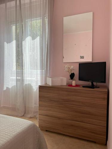a bedroom with a television on a dresser with a window at Il Tramonto in Altino