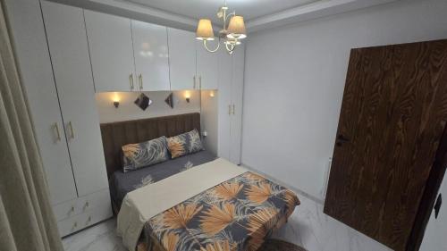 1 dormitorio pequeño con 1 cama y armario en Cozy hotel-style emerald apartment, en El Aouina Station