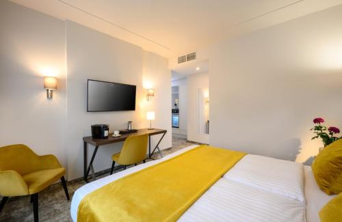 a hotel room with a bed and a desk at Leonardo Boutique Hotel Budapest M-Square in Budapest