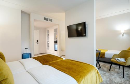 a bedroom with a bed and a tv on a wall at Leonardo Boutique Hotel Budapest M-Square in Budapest