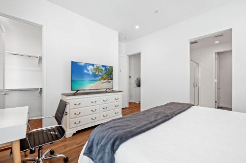 a bedroom with a bed and a desk and a tv at Central Location Master Bedroom w Shared Bathroom in Irvine