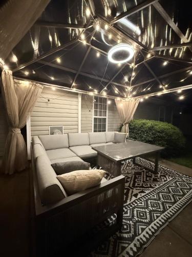 a patio with a couch and a table and lights at Queen City family-friendly entire house, Charlotte in Charlotte