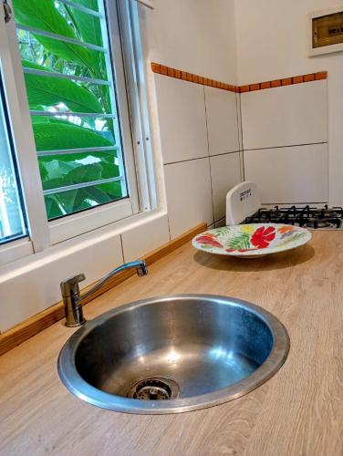 a stainless steel sink in a kitchen with a window at Quédate Aquí También in Las Galeras