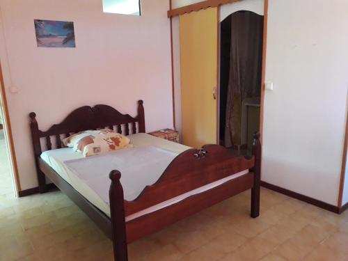 une chambre avec un lit en bois dans une pièce dans l'établissement la mirabelle le vauclin, au Vauclin