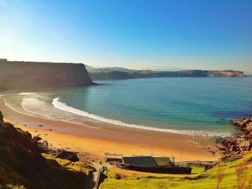 a view of a beach with the ocean at Apartamentos Catamarán Azul in Suances