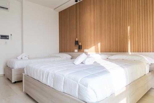 two white beds in a bedroom with wooden walls at La Terrazza sul Mare in Praia a Mare
