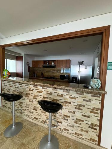 a kitchen with two bar stools in front of a counter at Marabierto Beachfront Escape in Arizona