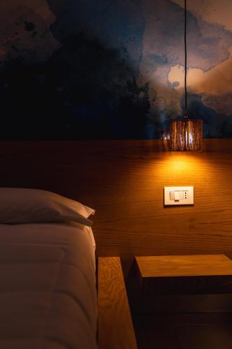 a bedroom with a bed and a light on the wall at La Terrazza sul Mare in Praia a Mare