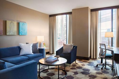 a living room with a blue couch and a table at The Royal Sonesta Chicago River North in Chicago