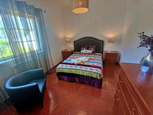 a bedroom with a bed and a chair at Recanto da Tia in Póvoa de Santa Iria