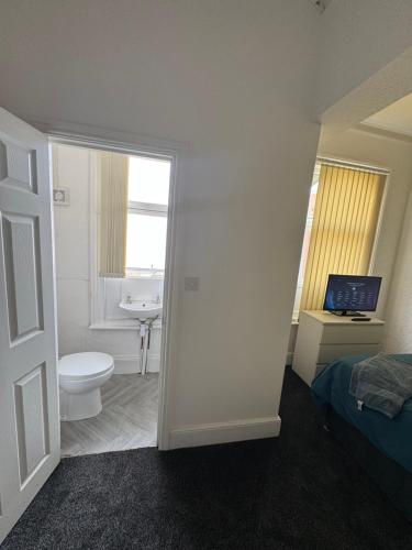 a bathroom with a toilet and a sink at The Cozy House in Wolverhampton