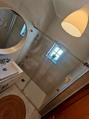 a bathroom with a shower and a sink and a mirror at Recanto da Tia in Póvoa de Santa Iria