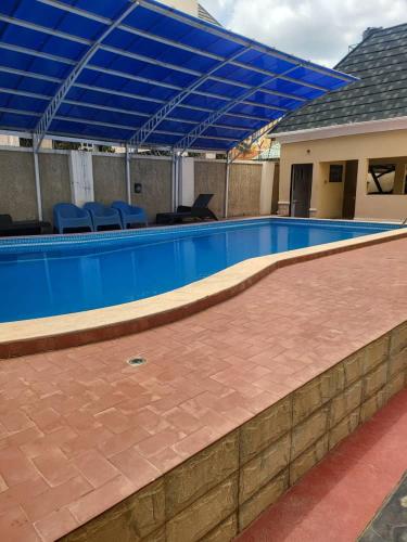 a swimming pool with a blue canopy over it at The Perfect Place in Gwarinpa