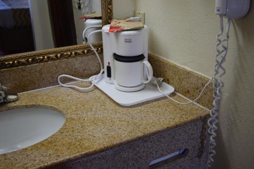 a coffee maker on a counter next to a sink at Travelodge Inn & Suites by Wyndham Norman in Norman