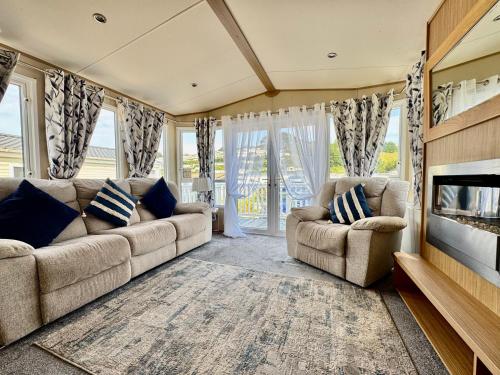 ein Wohnzimmer mit Couch und Kamin in der Unterkunft The Windermere- Luxury Caravan Retreat by the Sea in Devon in Burgh Island