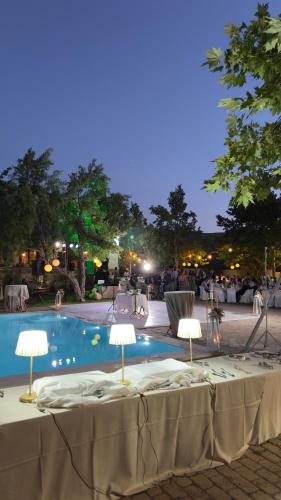 a table with two lamps next to a swimming pool at Villa OINOI with Pool for Luxury Vacation and Events in Marathón