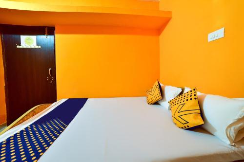 a bed with pillows on it in a room at Hotel O Lucky Guest House in Khagaul