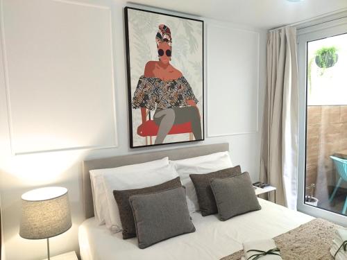 a bedroom with a bed with a painting above it at Cais das Pedras Pátio Apartment - with washer and dryer machine in Porto