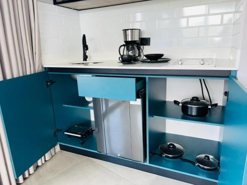 a kitchen with a blue and white counter with pots and pans at Hotel Living 35 Suites in Medellín