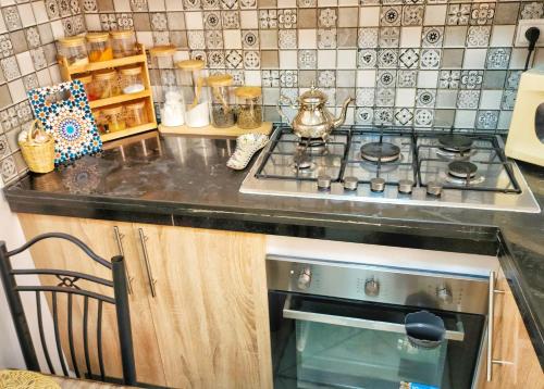 a kitchen with a stove with a tea kettle on it at Appart calme près château rouge in El Jadida