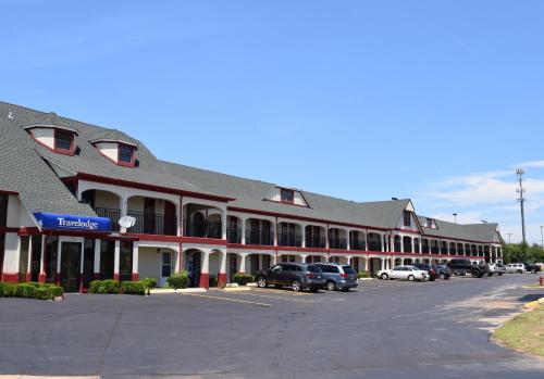 a large building with cars parked in a parking lot at Travelodge Inn & Suites by Wyndham Norman in Norman
