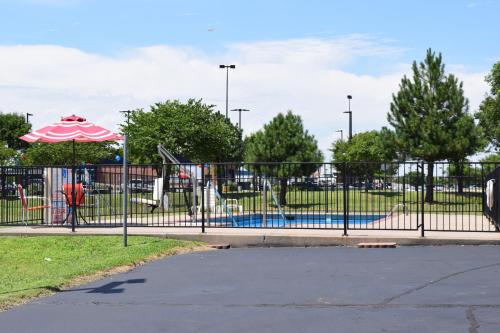 a park with a playground with an umbrella at Travelodge Inn & Suites by Wyndham Norman in Norman