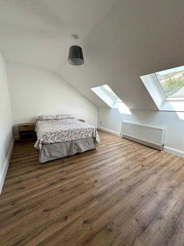 an attic bedroom with a bed and skylights at Railway House, Halfway in Ballinhassig