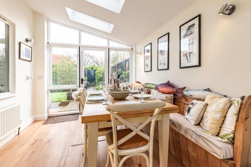 a dining room with a table and a couch at Cobblers in Theberton