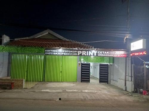 a green garage door with a sign on it at Touchsmart in Lemahabang