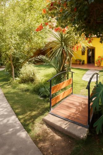 a bench sitting on a wooden walkway in a yard at HOTEL HALLEY - Vicuña, Valle de Elqui in Vicuña