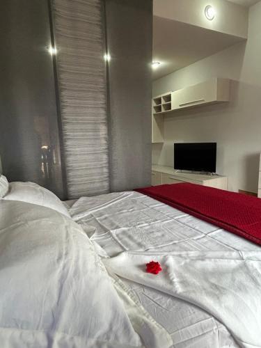 a white bed with a red rose on it at Marianna Guest House in Bracciano