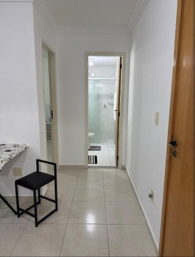 a room with a chair and a hallway at Apto mobiliado no edificio saveiro com garagem in São José dos Campos
