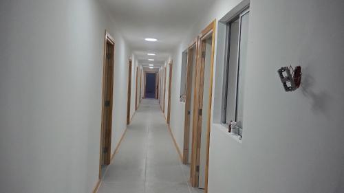 a hallway with white walls and a long hallway at Hostal GYT in Caldera