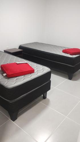three beds sitting on top of a white floor at Hostal GYT in Caldera