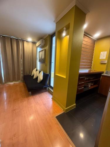 a living room with a couch and a yellow wall at MODERNO TURISTICO Y EJECUTIVo in Santiago