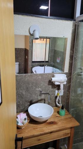 a bathroom with a sink and a mirror at Suítes La Reserve in Campos do Jordão