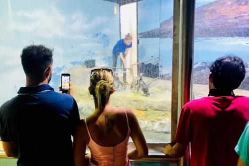 a group of three people looking at a painting at Santos Prime Stay in Santos
