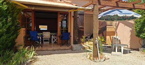 a patio with an umbrella and a table and chairs at Bella Vista Colline Valmer in La Croix-Valmer