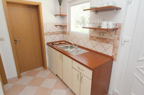 a small kitchen with a sink and a window at Apartments Kala in Sveti Filip i Jakov