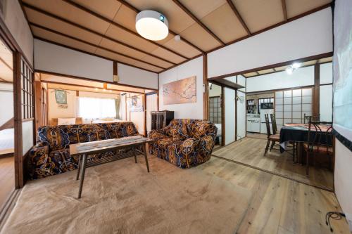 a living room with a couch and a table at Former Yoshidaya Hikonana Residence, a Registered Tangible Cultural Property 倉敷の宿 国登録有形文化財 旧吉田彦七邸 一棟貸切 1日1組限定 特別な体験 日本の伝統建築で過ごす非日常を in Kurashiki