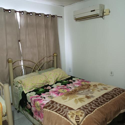 a bed sitting in a room with a curtain at Pousada Maria Guapa in São Gabriel