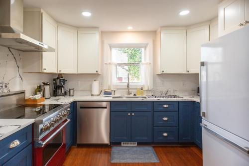 a kitchen with blue cabinets and a white refrigerator at Modern Mill House Walk to Downtown Durham in Durham